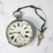 An antique silver pocket watch with key