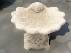 A concrete shell bird bath,
