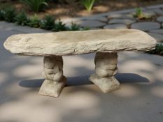 A rustic concrete garden bench on squirrel supports,