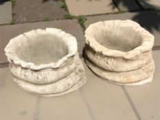 A pair of concrete sack planters,