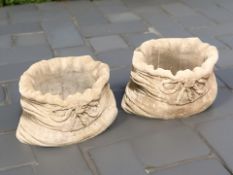 A pair of concrete sack planters,