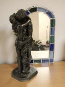 A bronzed figure of two lovers embracing, and a stained and leaded glass mirror,