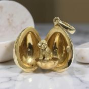 A Fabergé 18ct gold, enamel and diamond egg charm pendant containing a puppy, numbered 15/1000,
