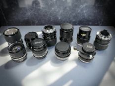 A collection of vintage film camera lenses to include Vivitar 1:2.8-3.8 35-70mm lens, Canon FD 1:1.