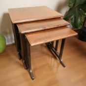 A reproduction mahogany nest of three tables,