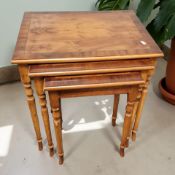 A reproduction yew wood nest of three tables, width 51 cm.
