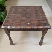 A carved and stained wooden chess board table,