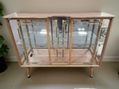 A 1960's glazed teak cocktail cabinet with sliding doors,