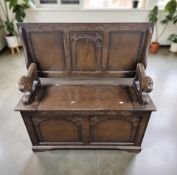 A stained oak storage monk's bench, 96 cm x 44 cm x 97 cm H overall.