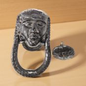 A painted metal door knocker in the form of a pharaoh, length 16 cm.