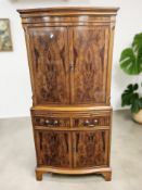 A reproduction yew wood serpentine front drinks cabinet, 73 cm x 49 cm x 153 cm.