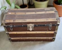 An early 20th century canvas and wooden bound domed trunk, width 83 cm.