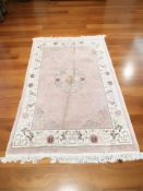 A Chinese rug on pink ground, 201 cm x 121 cm.
