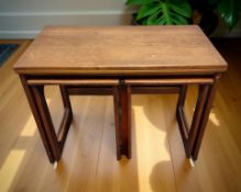 A teak turnover top table on castors, fitted two stowaway tables beneath, width 75 cm.