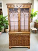 A reproduction yew wood glazed double door display cabinet, 102 cm x 36 cm x 198 cm.
