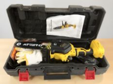 A hand held electric chain saw, boxed with instructions.