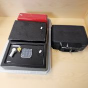A digital safe with key, a Masterlock strong box with key and two further tin boxes.