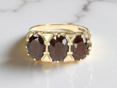 A 9ct gold three stone garnet ring, size P½ CONDITION REPORT: 3.