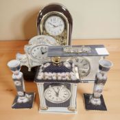 A Past Times porcelain quartz mantel timepiece garniture set, and three further timepieces.