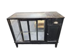 An early 20th century ebonised and glazed shop counter,