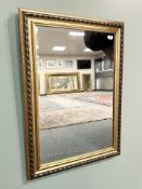 A contemporary bevelled over mantel mirror, 77 cm x 106 cm.