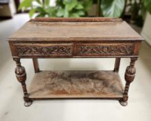 An Edwardian carved oak two drawer side table, 106 cm x 47 cm x 77 cm.