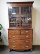 A George III mahogany bow front five drawer chest with glazed double door bookcase above,