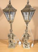 A pair of brass table lamps in the form of children stand beneath lampposts, height 66 cm.