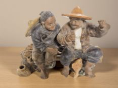 A Chinese earthenware group of two figures sat on a bench, width 35 cm.