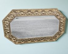 An embossed brass octagonal mirror, width 75 cm.