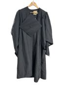 A black graduation gown with mortarboard hat.