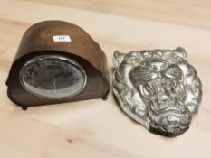 An Art Deco oak mantel clock and a silvered tiger's head plaque.