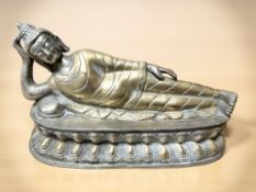 An oriental cast and patinated figure of Buddha reclining,