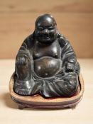A hollow cast bronze figure of Buddha on wooden plinth, height 14 cm.