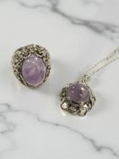 A silver pendant on chain,