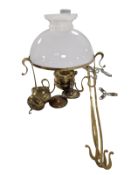A brass and opaque glass hanging oil lamp.