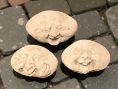 Three concrete garden laughing face stones,