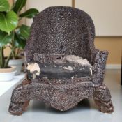 A late 19th century Burmese heavily carved hardwood armchair,