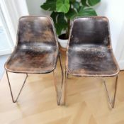 A pair of 20th century industrial enameled metal and faux leather bucket chairs.