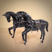 Two leather figures of prancing horses, length 50 cm.