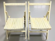A pair of painted folding wooden garden chairs.