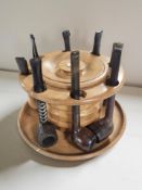 A circular pipe rack incorporating a tobacco pot, with several pipes.
