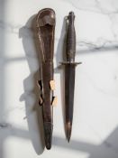 A Fairbairn-Sykes Third-Pattern commando fighting knife, with leather sheath.