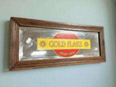 A rectangular mirror with applied Wills Gold Flake Cigarettes decoration, width 53 cm.