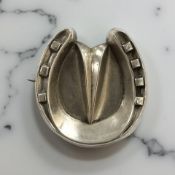 An antique silver horseshoe brooch
