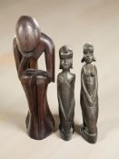 A pair of African carved hardwood figures, height 25 cm, and a further figure.