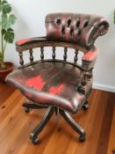 A reproduction mahogany and oxblood buttoned leather captain's swivel desk armchair, width 65 cm.
