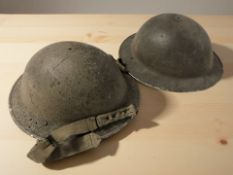 Two British military tin helmets.