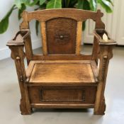 A 1920's oak storage monk's hall seat, with umbrella drip trays beneath armrests,