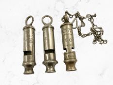 Two vintage ARP whistles together with a Metropolitan police whistle